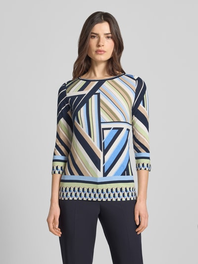 Vrouwenmodel draagt Blusenshirt mit 3/4-Arm van Betty Barclay, mix van viscose en elastaan, recht model, ronde hals, ruglengte maat 36: 60 cm, geometrisch patroon in blauw, beige en groen, gladde stof, Ganzkörperansicht van voren.