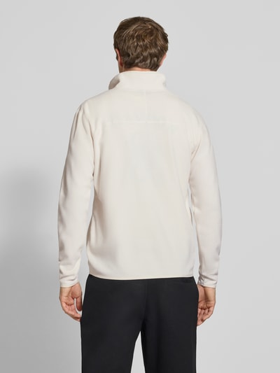 Männermodel trägt Fleecepullover mit Label-Stitching von The North Face in Creme, Stehkragen, Regular Fit, Ganzkörperansicht Rückansicht, Rückenlänge 70 cm, Ärmellänge 68 cm.