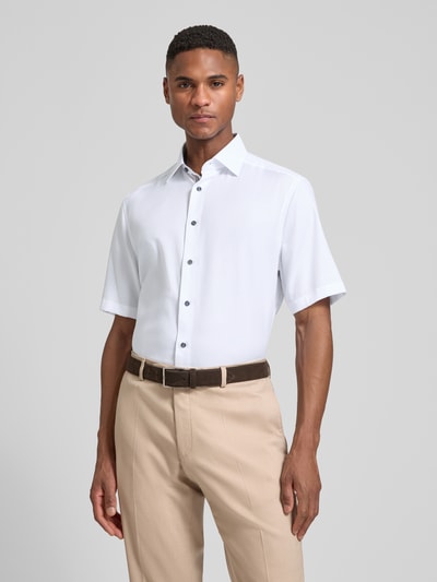 Männermodel trägt Regular Fit Business-Hemd mit Kentkragen von OLYMP, reine Baumwolle, unifarben, 1/2-Arm, Ganzkörperansicht von vorne.