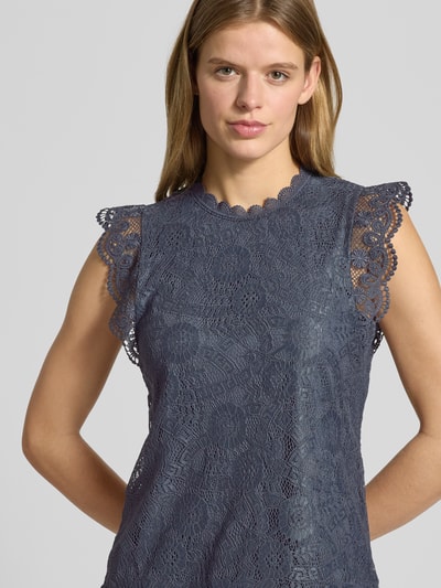 Vrouwenmodel draagt Shaped Fit Blusentop met Spitzenbesatz Model 'OLLINE' van Pieces, look effen, bloemenmotief, kant, ronde hals, applicatie met labelstitching, 1-knoopssluiting, druppelvormige hals aan de rug, detailopname bovenlichaam.