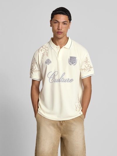 Männermodel trägt Poloshirt floralem Allover-Stitching von Don´t Waste Culture in Creme mit Relaxed-Fit, Logo-Print, Polokragen, Kurzärmelig, Rückenlänge 71 cm, Ganzkörperansicht von vorne.