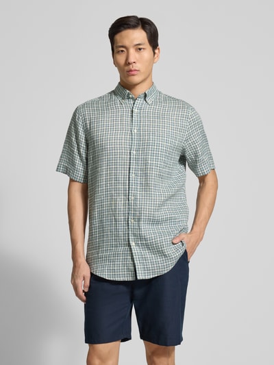Männermodel trägt Regular Fit vrijetijdsoverhemd van linnen van Christian Berg Men met button-downkraag, knoopsluiting, borstzak, ruitpatroon, kleuren groen en wit, heren, ruglengte maat M 81 cm, schouderbreedte 54 cm, mouwlengte 28 cm, voorkant geheel zichtbaar, Ganzkörperansicht von vorne.