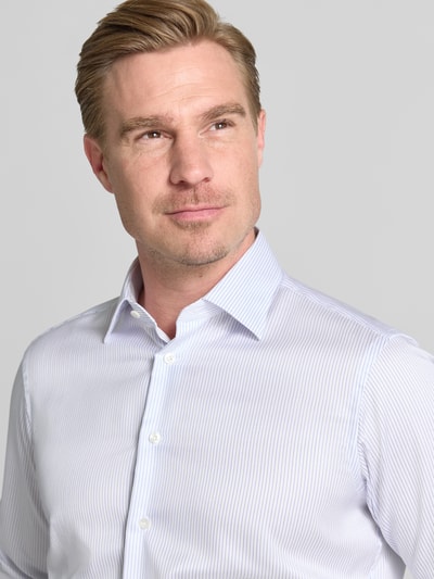 Mężczyznamodel nosi Regular Fit Business-Hemd in hochwertiger Two Ply Qualität von Christian Berg Men, biała, jednokolorowa bawełna, kołnierzyk typu cutaway, splot twill, krój regular fit, długość tyłu w rozmiarze 39/40: 79 cm, szerokość w rozmiarze 39/40: 40 cm, długość rękawów w rozmiarze 39/40: 66 cm, zdjęcie: zbliżenie na górną część ciała z przodu.