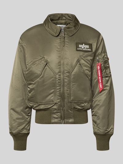 Produktfoto, Bomberjacke mit seitlichen Pattentaschen und Label-Patch von Alpha Industries in Olivgrün, Reißverschluss, glatte Oberfläche, gerippte Abschlüsse