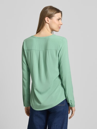 Frauenmodel trägt Regular Fit Bluse aus reiner Viskose mit Tunika-Ausschnitt von Christian Berg Woman in sanftem Grün, Knopfleiste, langärmeliges Design, Rückenlänge 64 cm bei Größe 36, Ärmellänge 60 cm, Ganzkörperansicht Rückansicht.