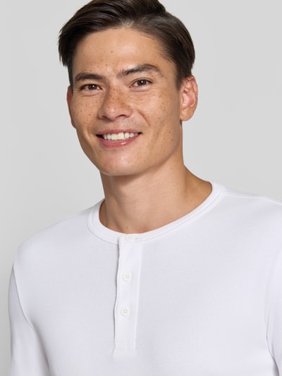 Męski model nosi t-shirt in Ripp-Optik mit Rundhalsausschnitt von Jake*s, mieszanka bawełny i elastanu, krój slim fit, długość tyłu 56 cm, zbliżenie na górną część ciała.
