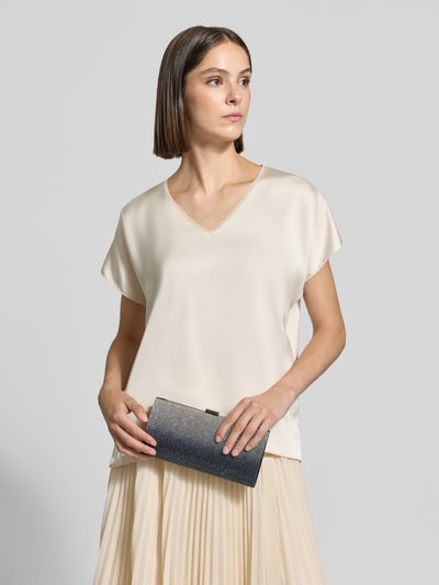 Modelka nosi kopertówkę 'Abendtasche mit Ziersteinbesatz' od Jake*s Cocktail w ciemnym kolorze z obszyciem ozdobnymi kamieniami, zbliżenie na górną część ciała, widok z przodu.