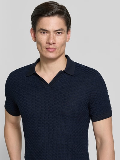 Męski model nosi Regular Fit Strick-Poloshirt Modell 'TONO' od CINQUE, bawełniana mieszanka, wzór strukturalny, kolor granatowy, krój regular fit, dekolt w szpic, długość tyłu w rozmiarze M: 67 cm, zbliżenie górnej części ciała.
