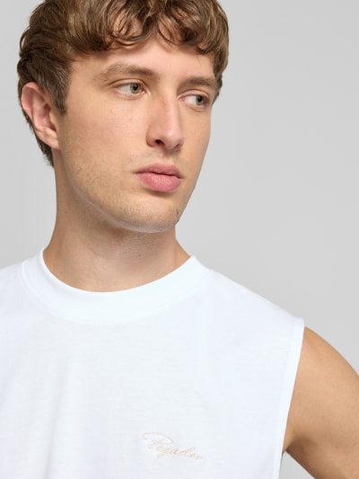 Männermodel trägt Tanktop mit Label-Stitching und Rundhalsausschnitt von Pegador aus Reine Baumwolle im Relaxed-Fit, Nahaufnahme Oberkörper.