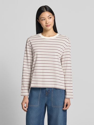 Frauenmodel trägt Boxy Fit Langarmshirt aus reiner Baumwolle Modell 'ESSENTIAL' von Selected, beige mit braunen Streifen, Damen Langarmshirt, Ganzkörperansicht von vorne.