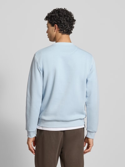 Męski model nosi Sweatshirt mit gerippten Abschlüssen Modell 'BRADLEY' od Jack & Jones, kolor jasnoniebieski, krój regular fit, mieszanka materiałów z bawełną, ściągacze, okrągły dekolt, długość tyłu w rozmiarze M: 67 cm, długość rękawa: 65 cm, widok całej sylwetki z tyłu.