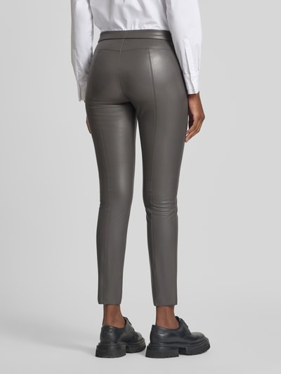 Frauenmodel trägt Skinny Fit Kunstlederhose mit elastischem Bund Modell 'RESA' von Raffaello Rossi in Grau, Damen Leder- / Kunstlederhose, Ganzkörperansicht Rückansicht.