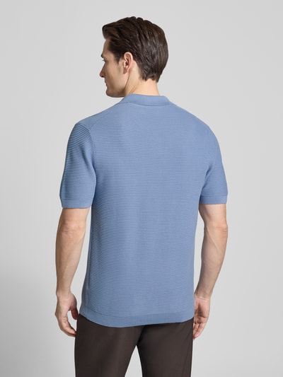 Männermodel trägt Strickshirt mit Polokragen und V-Ausschnitt von Christian Berg Men, Reine Baumwolle, Regular-Fit, Rückenlänge 73 cm, Ärmellänge 27 cm, hellblau mit feiner Rippenstruktur, Ganzkörperansicht Rückansicht.
