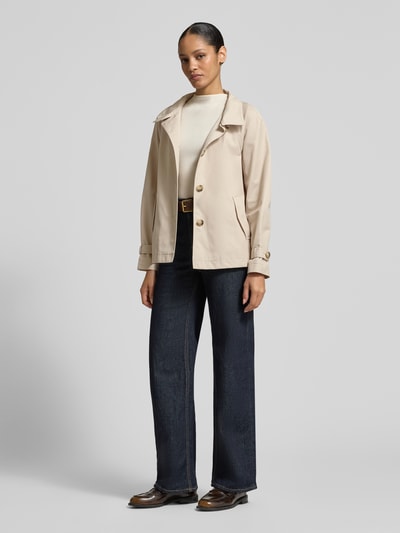 Frauenmodel trägt Jacke mit Stehkragen und Ärmelriegeln von Fuchs Schmitt in Beige, Baumwoll-Mix, Eingrifftaschen, Knopfleiste, Ganzkörperansicht von vorne.