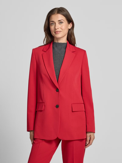 Vrouwenmodel draagt Regular Fit Longline Blazer mit Pattentaschen van JAKE*S WOMAN collectie in rood met sierknopen, deelnaden, knopen, kraag, schoudervullingen, loopsplit, 2-knoopsluiting, klepzaken, lange mouwen, vooraanzicht van het bovenlichaam.