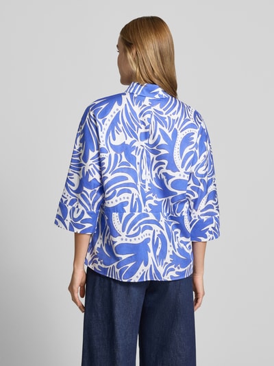 Frauenmodel trägt Bluse mit verdeckter Knopfleiste und 3/4-Arm von Christian Berg Woman aus reiner Baumwolle mit blau-weißem Muster, Regular Fit, hemdbusenkragen, abgerundetem Saum, Rückenlänge 64 cm, Ärmellänge 24 cm, Ganzkörperansicht Rückansicht.