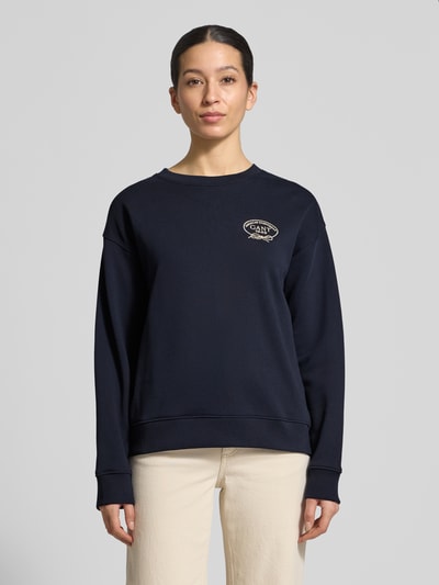 Frauenmodel trägt Sweatshirt mit Label-Stitching und Rundhalsausschnitt von Gant, Baumwolle, Loose Fit, navyblau, Ganzkörperansicht von vorne.