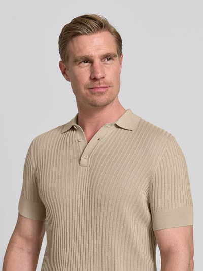 Männermodel trägt Slim Fit Poloshirt aus Viskose-Mix von Antony Morato in Beige, Strick-Optik, Polokragen, Kurzärmelig, Nahaufnahme Oberkörper.