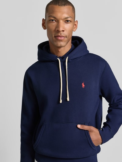 Mannenmodel draagt Regular Fit Hoodie uit katoenmix van Polo Ralph Lauren, donkerblauw met rood logo, Nahaufnahme Oberkörper, Heren hoodie