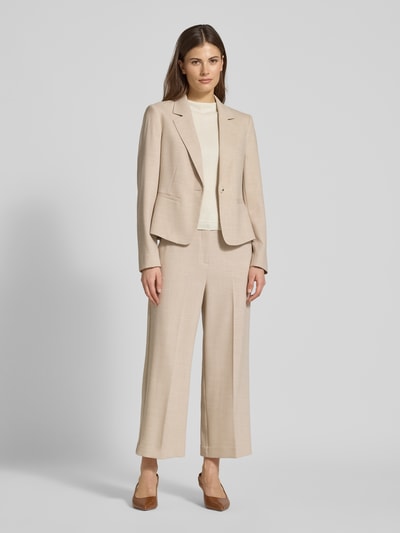 Frauenmodel trägt Relaxed Fit Stoffhose mit Viskose-Anteil und Bügelfalten von Comma, Elastischer-Material-Mix, Eingriff- und Gesäßtaschen, Ganzkörperansicht von vorne.