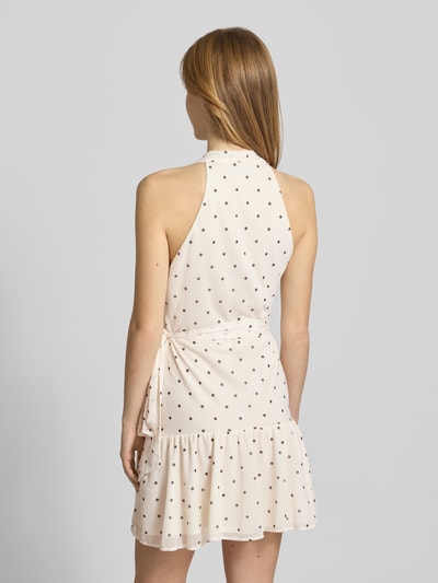 Modelka kobieca nosi 'Minikleid mit Neckholder' od Gina Tricot, kremowy kolor, w kropki, z paskiem, krój slim fit, długość 83 cm, szerokość w rozmiarze S: 38 cm, sukienka z przekładanym przodem, widok całej sylwetki z tyłu.