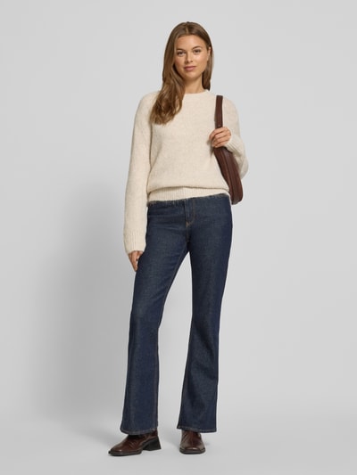 Modelka kobieca ma na sobie Regular Fit Strickpullover mit Woll-Anteil od Tom Tailor o melanżowej optyce, krój regular fit, okrągły dekolt, długie rękawy z prążkowanymi ściągaczami, dzianina o strukturze prążkowanej; pełny widok z przodu.