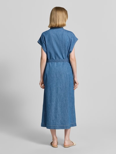 Frauenmodel trägt Regular Fit Jeanskleid aus reiner Baumwolle von s.Oliver RED LABEL in mittlerem Blau mit Kontrastnähten, Ganzkörperansicht Rückansicht.