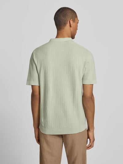Męski model nosi Regular Fit Poloshirt aus Baumwoll-Leinen-Mix Modell 'MATTIS' von SELECTED HOMME, efekt: jednolity kolor, z fakturą, krój regular fit, naszywka z logo, kołnierzyk polo, dekolt w serek, krótki rękaw, mieszanka bawełny i lnu, Ganzkörperansicht Rückansicht.