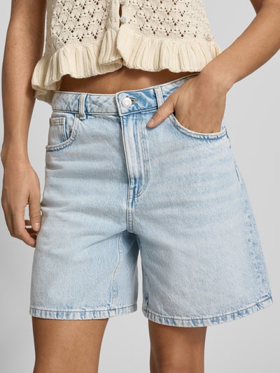 Frauenmodel trägt Jeansshorts mit Eingrifftaschen von REVIEW aus Reine Baumwolle im Regular-Fit, helle Waschung, Nahaufnahme Oberkörper.