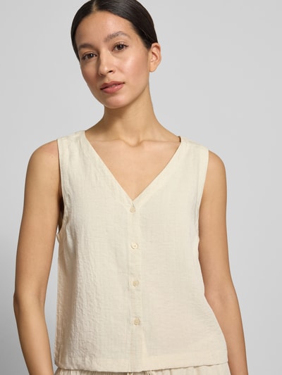 Frauenmodel trägt Regular Fit Bluse Aus Viskose-Mix Modell 'Daria' von MSCH Copenhagen in Creme mit durchgehender Knopfleiste, Ärmelloses-Design, V-Ausschnitt und dezenter Struktur für Damen, Nahaufnahme Oberkörper. Kontext: Bluse aus Viskose-Mix mit Leinen-Anteil, Rückenlänge bei Größe S: 49 cm.