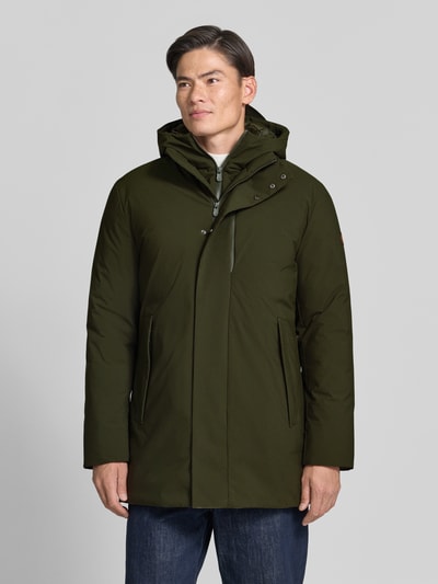 Männermodel trägt lange jas met capuchon en borstzak Model 'SESLE' van Save The Duck in olijfgroen, recht model, steekzakken, ritssluiting, klittenbandsluiting, gebreide mouwboorden, detail opname van voren.