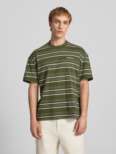 Männermodel trägt Herren T-Shirt mit Logo-Stitching Modell 'EAST LIBERTY' von Dickies, Reine Baumwolle, Relaxed-Fit, Rundhalsausschnitt, grün mit weißen Streifen, Rückenlänge bei Größe M 68 cm, Ganzkörperansicht von vorne.