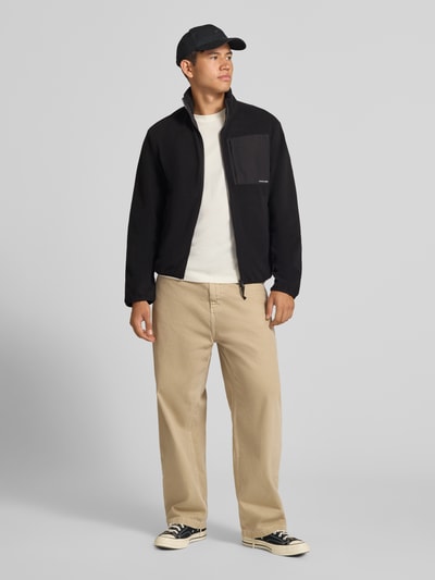 Männermodel trägt Fleecejacke mit Zweiwege-Reißverschluss Modell 'MASON' von JACK & JONES in Schwarz, Stehkragen, Regular Fit, Ganzkörperansicht von vorne