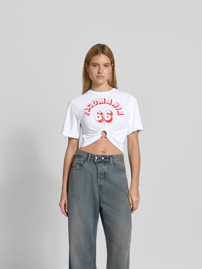 Frauenmodel trägt Cropped T-Shirt mit Zier-Detail von Rabanne, weiß mit Statement-Print, elastischer Baumwoll-Mix, Rundhalsausschnitt, Ganzkörperansicht von vorne