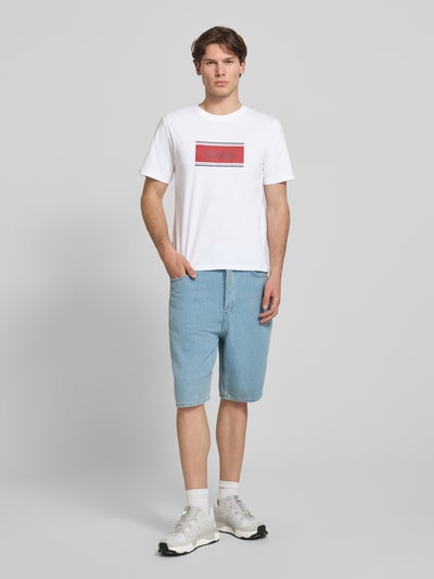 Männermodel trägt Regular Fit T-Shirt mit Logo-Print Modell 'Buster' von JACK & JONES aus Reine Baumwolle, Herren T-Shirt, Ganzkörperansicht von vorne. Rückenlänge bei Größe M: 71 cm.