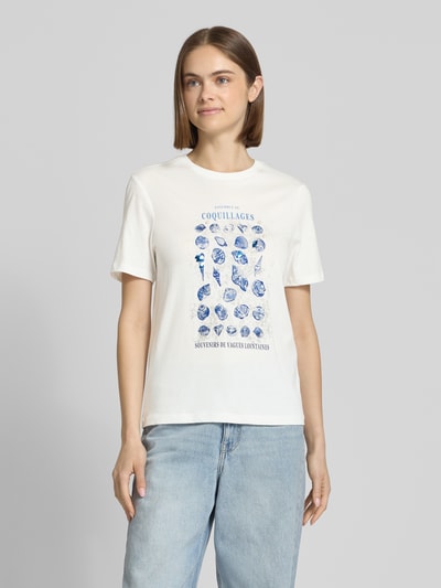 Frauenmodel trägt Regular Fit T-Shirt aus reiner Baumwolle Modell 'KITA' von Only, Optik: Unifarben, Motiv-Print mit Pailletten, Perlen, Glitzer-Print, Jersey, Rundhals, Kurzarm, Ganzkörperansicht von vorne.