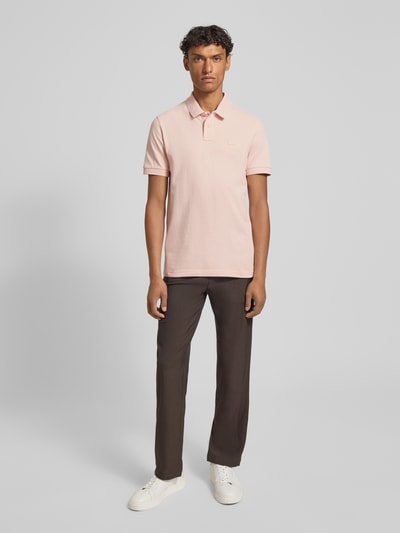 Męski model nosi Regular Fit Poloshirt aus Baumwoll-Mix Modell 'PASSENGER' von BOSS Orange, efekt: jednolity kolor, krój regular fit, wyhaftowane logo, kołnierzyk polo, dekolt w serek, krótkie zapięcie na guziki, krótki rękaw, prążkowane zakończenia rękawów, wykończenie materiału: pika, materiał: mieszanka bawełny; Ganzkörperansicht von vorne.