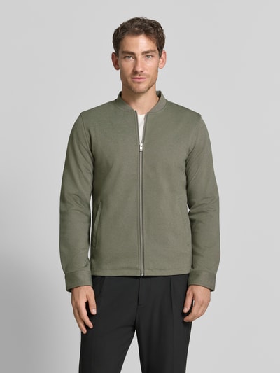 Mężczyzna nosi Slim Fit Sweatjacke mit Stehkragen od Lindbergh, Mieszanka materiałów z dodatkiem streczu, zamek błyskawiczny, wpuszczane kieszenie, krój slim fit, stójka, długość tyłu w rozmiarze M: 67 cm, długość rękawów w rozmiarze M: 66 cm, widok całej sylwetki z przodu.