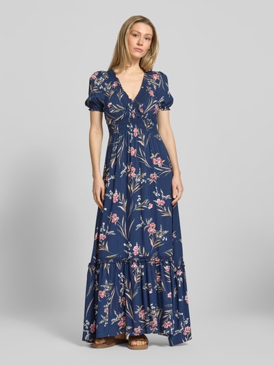 Modelka nosi Maxikleid aus Viskose mit V-Ausschnitt od Apricot, ciemnoniebieski kolor, kwiatowy wzór, elastyczna talia, długość maxi, cięcie A-linii, widok całej sylwetki z przodu.