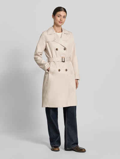 Frauenmodel trägt Trenchcoat mit Gürtel und seitlichen Eingrifftaschen von Zero in Beige, Taillierter Schnitt, Reverskragen, Doppelreihige Knopfleiste, Gürtel mit Dornschließe, Rückenlänge 100 cm, Schulterbreite 37 cm, Brustweite 50 cm, Ärmellänge 59 cm, Ganzkörperansicht von vorne.