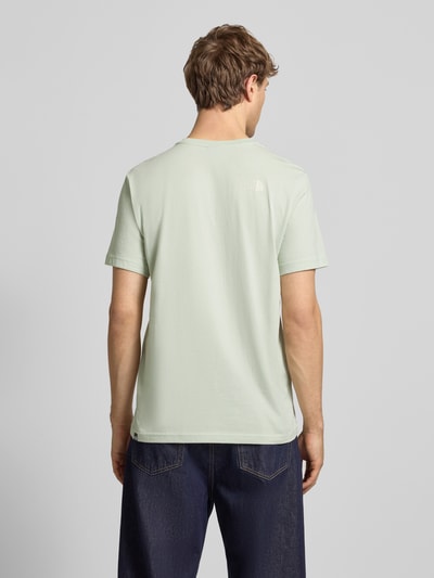 Męski model nosi T-shirt mit Label-Print von The North Face, mieszanka bawełny, krój regular fit, okrągły dekolt, długość tyłu 71 cm, Ganzkörperansicht Rückansicht.