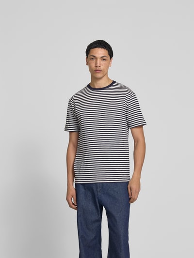 Männermodel trägt T-Shirt mit Rundhalsausschnitt von Closed, reine Baumwolle, schwarz-weiß gestreift, Regular Fit, Kurzarm, Ganzkörperansicht von vorne.