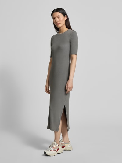 Frauenmodel trägt körpernahes Freizeitkleid aus Baumwoll-Mix Modell 'SEHAARAA' von Armedangels in Used Look, Midi-Länge, Rundhalsausschnitt, kurzarm, Seitenschlitz, Rippstruktur, Label Stitching, graue Farbe, Ganzkörperansicht von vorne.