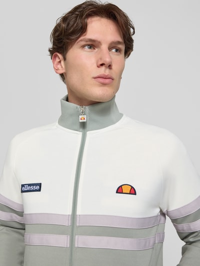 Männermodel trägt Trainingsjacke mit Label-Patch und Stehkragen Modell 'RIMINI' von ellesse, Baumwoll-Mix, Regular-Fit, Nahaufnahme Oberkörper.