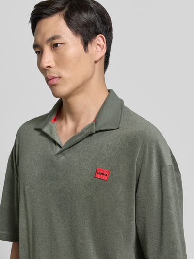 Männermodel trägt Regular Fit Poloshirt aus Baumwoll-Mix Modell 'TERRANCE' von HUGO, Optik: Unifarben, Label-Patch, Relaxed-Fit, Nahaufnahme Oberkörper.