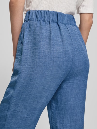 Vrouwenmodel draagt Hose in Denim-Optik model 'CHARISSA' van Soyaconcept in blue, wide leg, elastische band, detailopname rug. Context: dames broek, denimlook, wide leg, elastische band, bandwijdte maat S 36 cm, binnenbeenlengte maat S 75 cm.