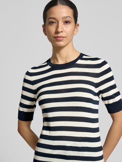 Frauenmodel trägt Shaped Fit Strickpullover aus reiner Schurwolle Modell 'Farbella' von BOSS, Optik: Unifarben, gestreift, Kurzarm, Feinstrick; Nahaufnahme Oberkörper.