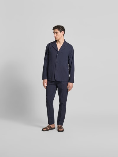 Männermodel trägt Relaxed Fit Hemdjacke aus Baumwolle von Officine Générale in Dunkelblau mit Knopfleiste, Brusttasche und Reverskragen, Ganzkörperansicht von vorne.