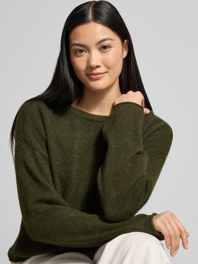 Frauenmodel trägt Strickpullover aus Woll-Mix Modell 'Kellsey' von MSCH Copenhagen in Dunkelgrün, Relaxed Fit, Nahaufnahme Oberkörper.