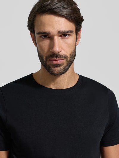 Męski model nosi T-Shirt z okrągłym dekoltem w 2-paku od MCNEAL, czarna bawełna, slim fit, zbliżenie na górną część ciała.